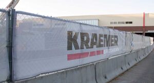 Fence Screen Mesh white construction banner hanging on a chain-link fence,