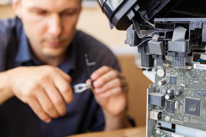 Man repairing a printer.