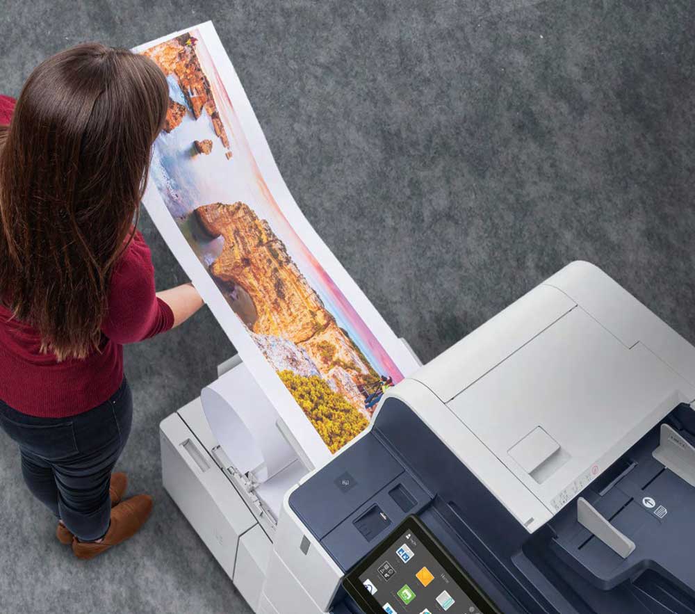 Managed Print Services 1 Overhead view of a woman at a Xerox printer.