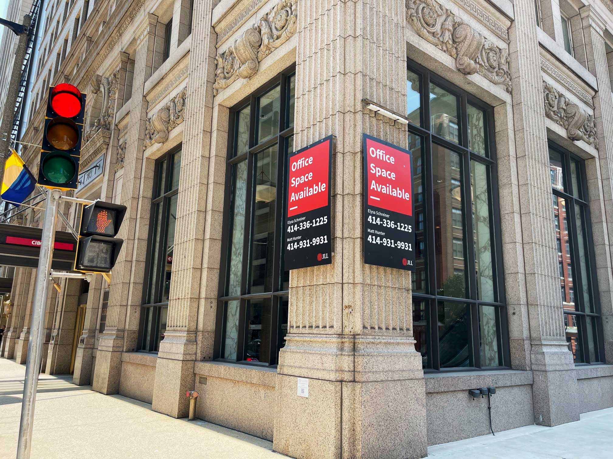 Durable Signage banners displayed on the corner of a historic stone building in downtown Milwaukee, advertising available office space.