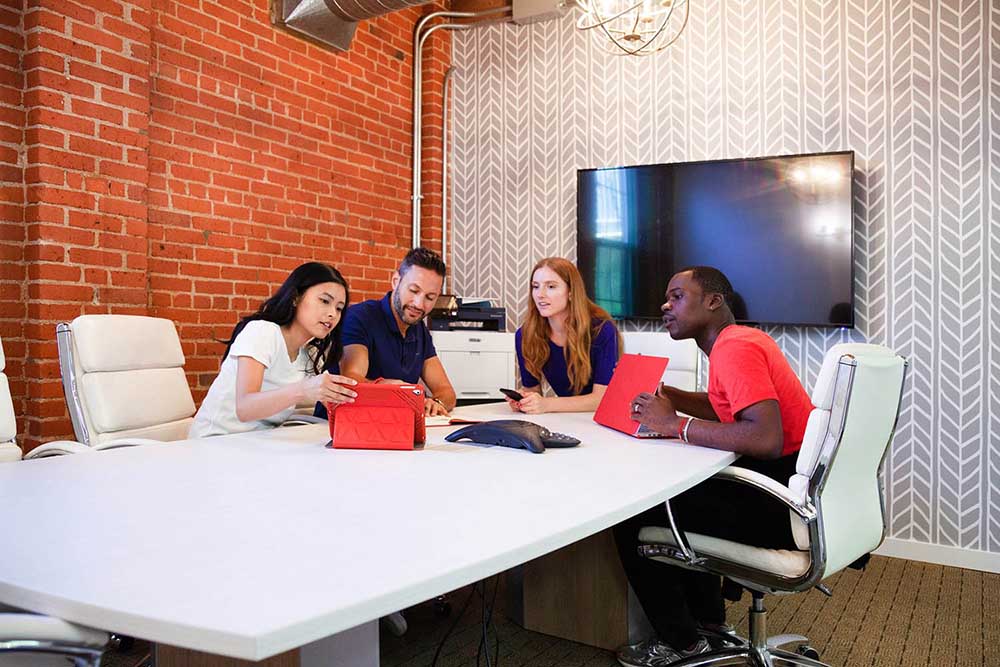 Xerox Printers 2 Coworkers meeting in a conference room.