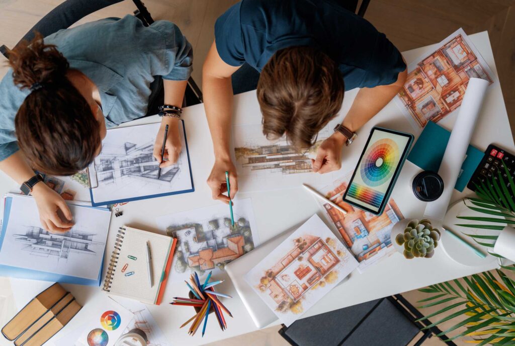 Portfolio Header image of two designers sketching and reviewing architectural plans, showcasing creativity, planning, and professional design services.