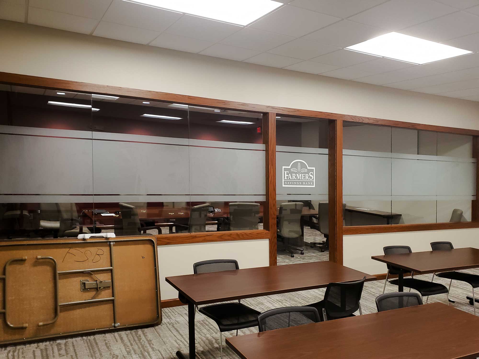 Frosted Window Film applied to a glass-walled conference room at Farmer's Savings Bank, offering privacy while maintaining a sleek, branded interior design.