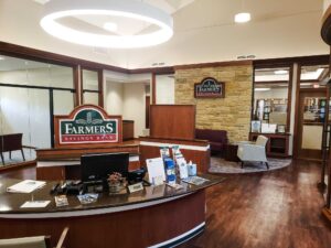 Environmental Graphics inside Farmer’s Savings Bank featuring branded signage, warm wood tones, and an inviting, professional interior layout.