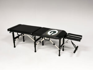 Thuli Tables custom black chiropractic table featuring the Green Bay Packers “G” logo, complete with adjustable headrest and foldable legs.